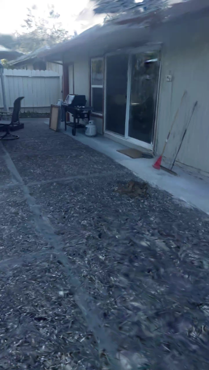 Render of the courtyard splat: the gravel yard beside the house with its sliding doors and barbecue, smeared at the edges.